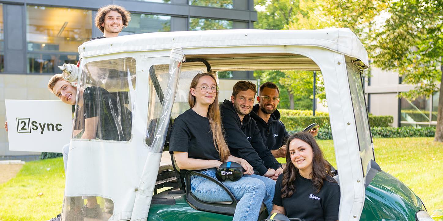 The team in the golf cart in front of our office